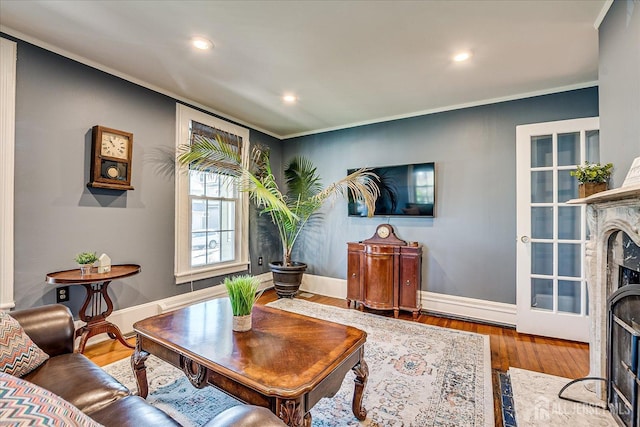 living area with recessed lighting, wood finished floors, baseboards, and a premium fireplace