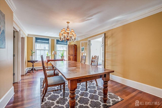 dining space featuring baseboards, an inviting chandelier, dark wood-type flooring, and crown molding