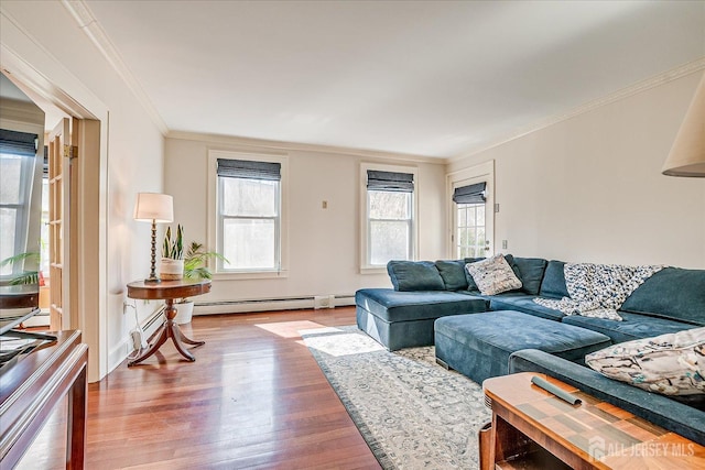 living room with baseboard heating, ornamental molding, and wood finished floors