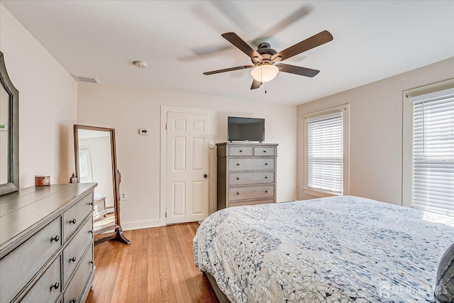 bedroom with visible vents, baseboards, ceiling fan, and light wood finished floors