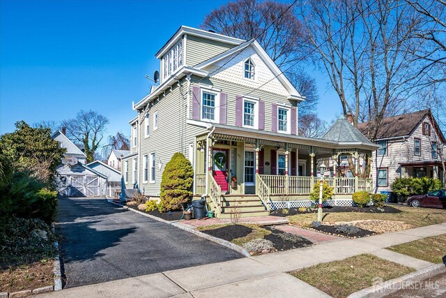 view of front of home with an outdoor structure and covered porch