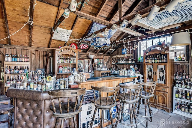 bar with a dry bar and vaulted ceiling