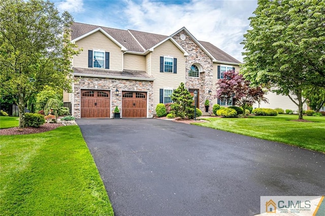 view of front of property featuring a garage and a front lawn