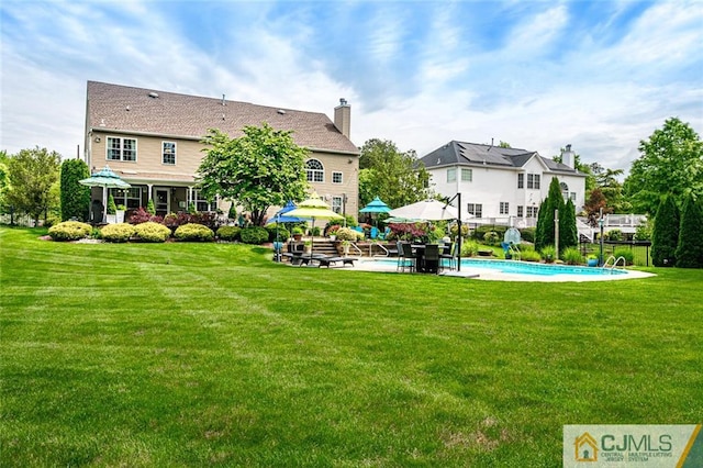 rear view of house with a lawn and a patio area