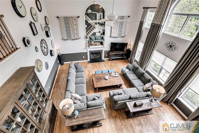 living room with hardwood / wood-style flooring and a towering ceiling