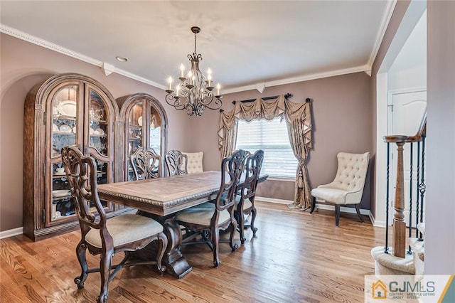 dining area featuring light hardwood / wood-style floors, ornamental molding, and an inviting chandelier