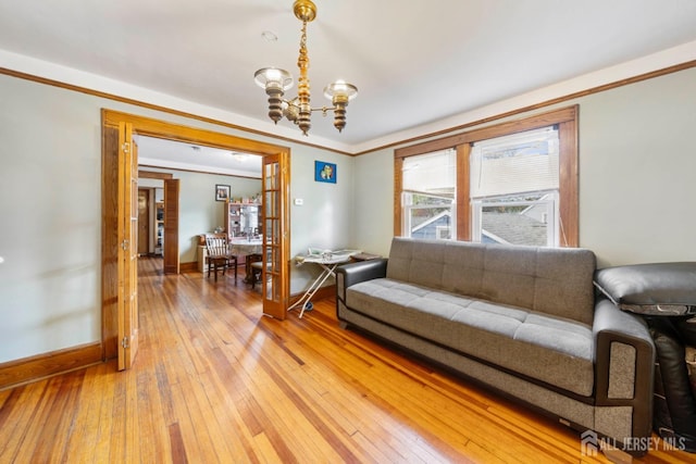 living room with ornamental molding, hardwood / wood-style flooring, and a notable chandelier