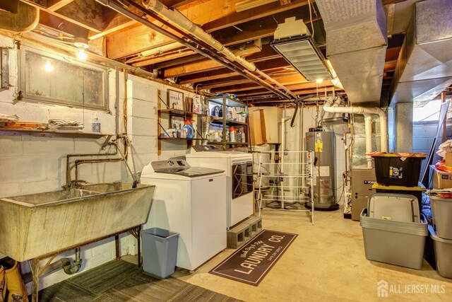 basement with washing machine and clothes dryer, sink, and water heater