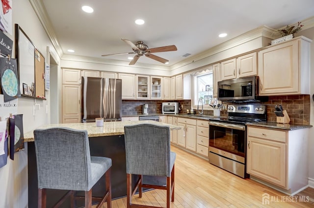 522 Hancock St, Middlesex, NJ 08846 - kitchen featuring appliances with stainless steel finishes, ornamental molding, a kitchen bar, decorative backsplash, and dark stone countertops