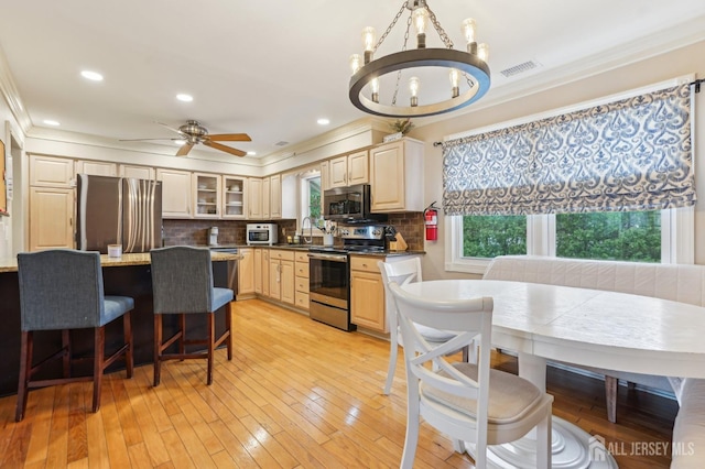 522 Hancock St, Middlesex, NJ 08846 - kitchen featuring appliances with stainless steel finishes, crown molding, a sink, a kitchen breakfast bar, and backsplash
