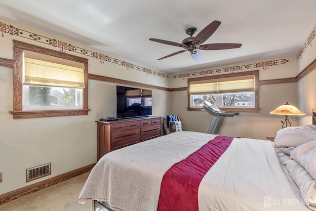 carpeted bedroom featuring visible vents, baseboards, and ceiling fan