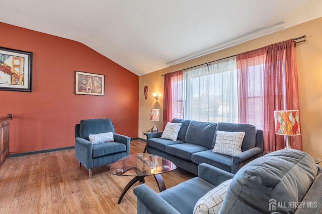 living area with light wood-type flooring, baseboards, and lofted ceiling
