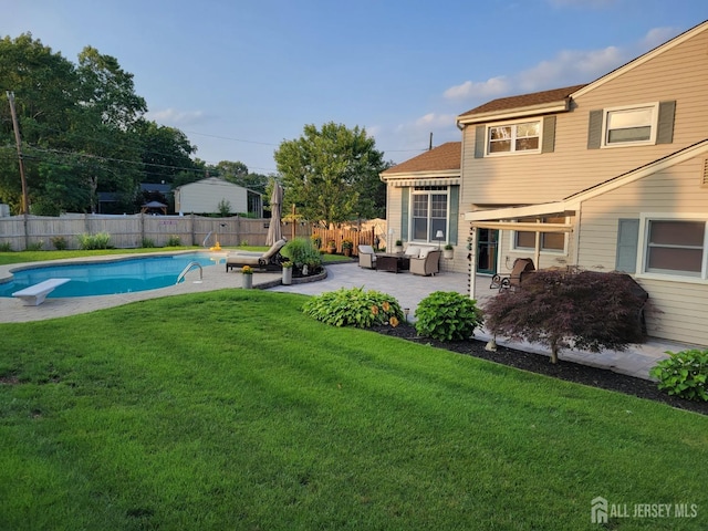 exterior space featuring a diving board, a fenced backyard, a lawn, a patio, and a fenced in pool