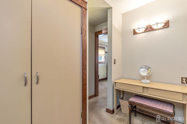 hall featuring carpet flooring and baseboards