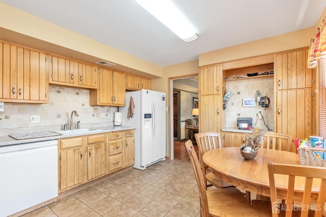 kitchen featuring light tile patterned floors, white appliances, tasteful backsplash, light countertops, and a sink