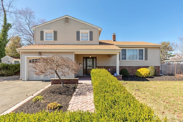 view of front facade featuring roof with shingles, a chimney, driveway, a garage, and fence