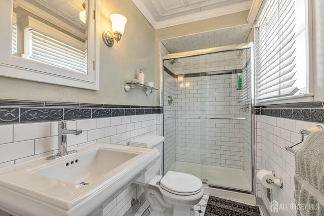 bathroom with a shower stall, a sink, tile walls, and ornamental molding