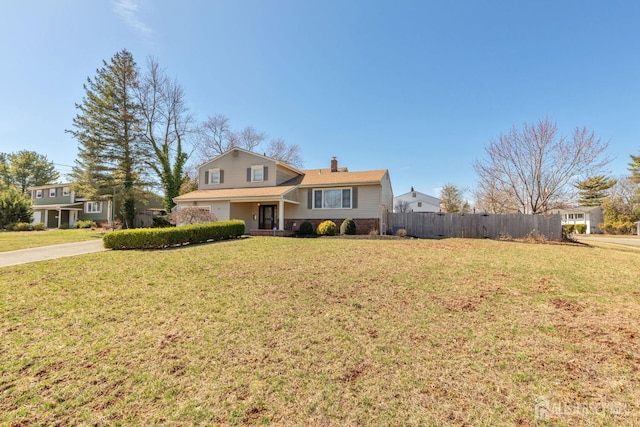 view of front of home with a chimney, concrete driveway, fence, and a front lawn