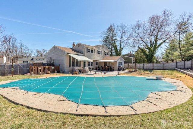view of swimming pool featuring a diving board, a fenced backyard, a lawn, a patio area, and a fenced in pool