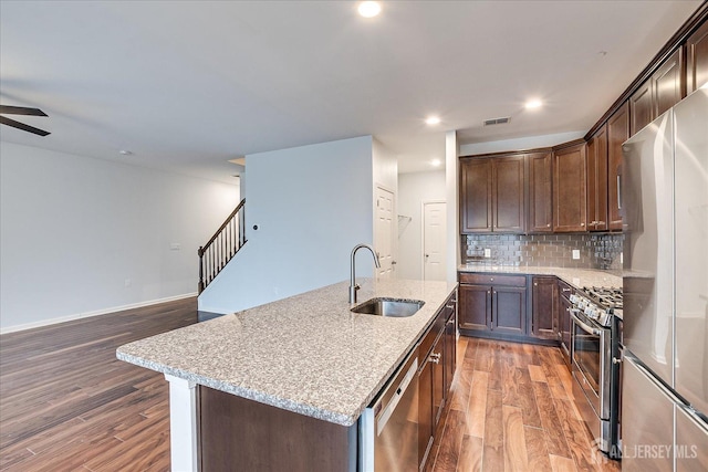 kitchen featuring stainless steel appliances, dark wood-type flooring, a sink, and visible vents