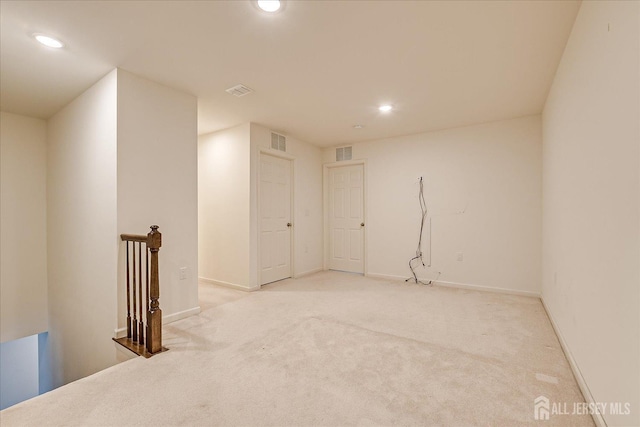 empty room featuring recessed lighting, visible vents, light carpet, and baseboards