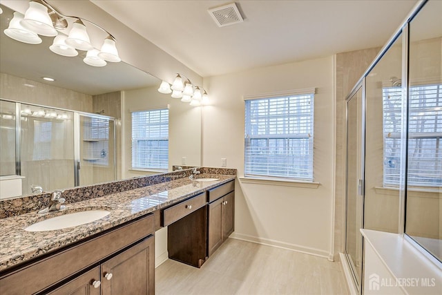 bathroom with a sink, visible vents, and a shower stall