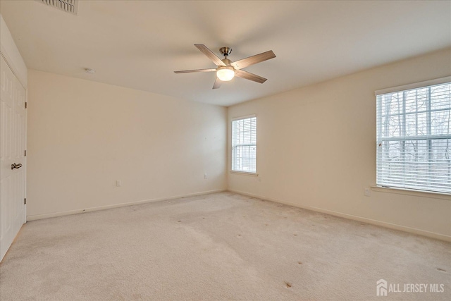 unfurnished room featuring ceiling fan, baseboards, visible vents, and light colored carpet