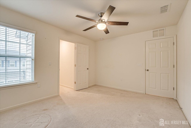 spare room featuring carpet, visible vents, and baseboards