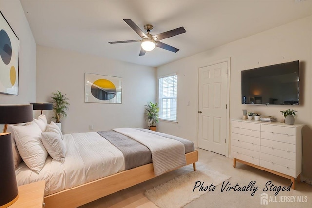 bedroom featuring light carpet and a ceiling fan