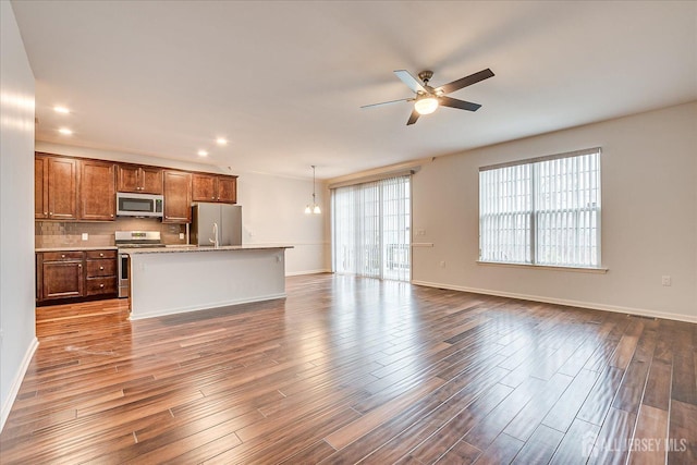 unfurnished living room featuring ceiling fan, baseboards, dark wood-style flooring, and recessed lighting