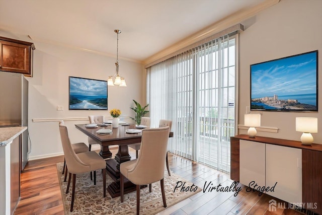 dining area featuring a chandelier, crown molding, baseboards, and wood finished floors