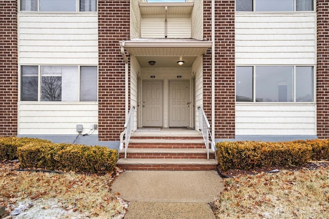 view of exterior entry with brick siding