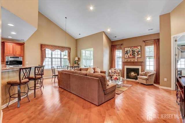 56 Kings Mill Rd, Monroe, NJ 08831 - living room featuring light wood-type flooring, a lit fireplace, baseboards, high vaulted ceiling, and recessed lighting