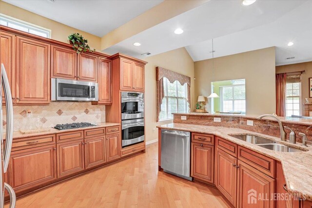 56 Kings Mill Rd, Monroe, NJ 08831 - kitchen featuring appliances with stainless steel finishes, a sink, brown cabinets, light wood-type flooring, and vaulted ceiling