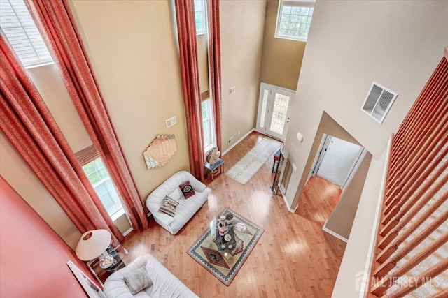 56 Kings Mill Rd, Monroe, NJ 08831 - unfurnished living room featuring a towering ceiling, light wood-type flooring, and baseboards