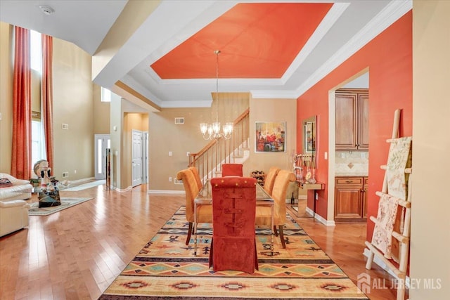 56 Kings Mill Rd, Monroe, NJ 08831 - dining area with stairway, light wood finished floors, a chandelier, a tray ceiling, and ornamental molding