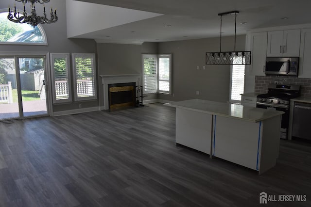 12 Juniper St, Metuchen, NJ 08840 - kitchen featuring stainless steel appliances, a chandelier, dark wood-style floors, a fireplace, and light countertops