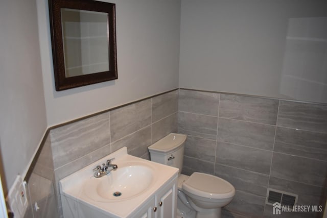12 Juniper St, Metuchen, NJ 08840 - bathroom featuring tile walls, toilet, vanity, and a wainscoted wall