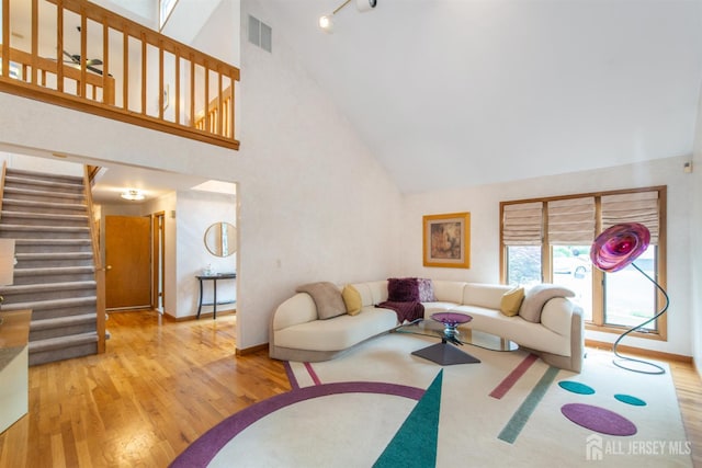 13 Clinton Ave, Edison, NJ 08820 - living area with wood finished floors, high vaulted ceiling, stairway, baseboards, and rail lighting