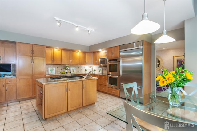13 Clinton Ave, Edison, NJ 08820 - kitchen with stainless steel appliances, an island with sink, decorative backsplash, light stone counters, and light tile patterned floors