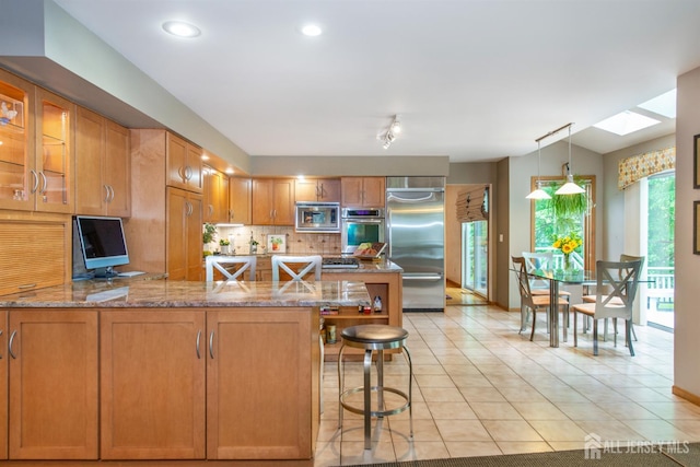 13 Clinton Ave, Edison, NJ 08820 - kitchen featuring built in appliances, a skylight, light stone countertops, decorative backsplash, and recessed lighting