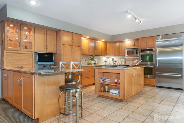 13 Clinton Ave, Edison, NJ 08820 - kitchen with built in appliances, stone counters, a breakfast bar, decorative backsplash, and light tile patterned floors