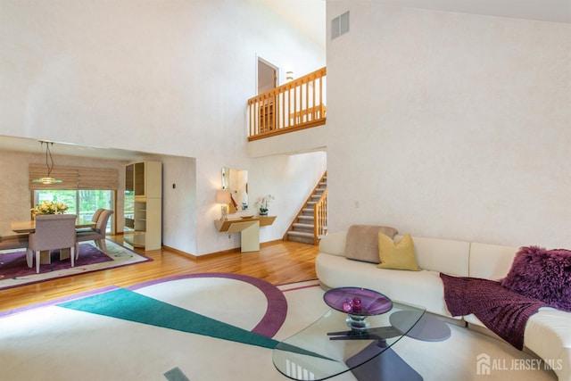 13 Clinton Ave, Edison, NJ 08820 - living area featuring wood finished floors, stairs, a towering ceiling, and baseboards