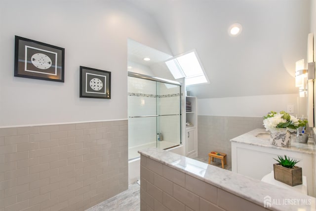 13 Clinton Ave, Edison, NJ 08820 - full bathroom featuring tile walls, a skylight, lofted ceiling, a tile shower, and vanity