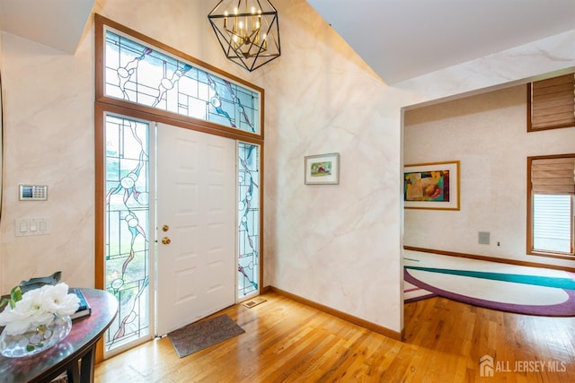13 Clinton Ave, Edison, NJ 08820 - foyer entrance with wood-type flooring, a chandelier, baseboards, and vaulted ceiling