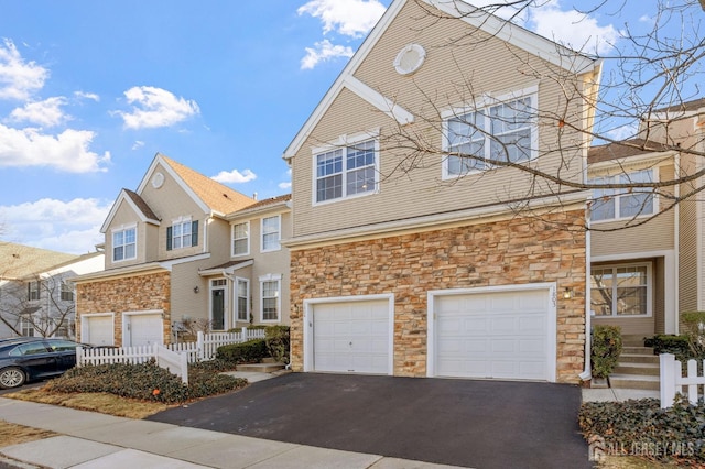 view of front facade featuring stone siding, a garage, and driveway