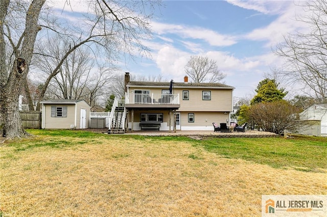 back of property with a wooden deck, a patio, a chimney, an outbuilding, and a shed