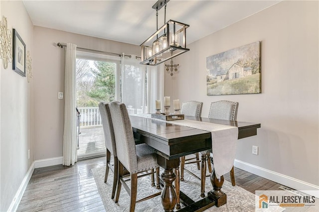 dining area featuring wood finished floors, baseboards, and a chandelier