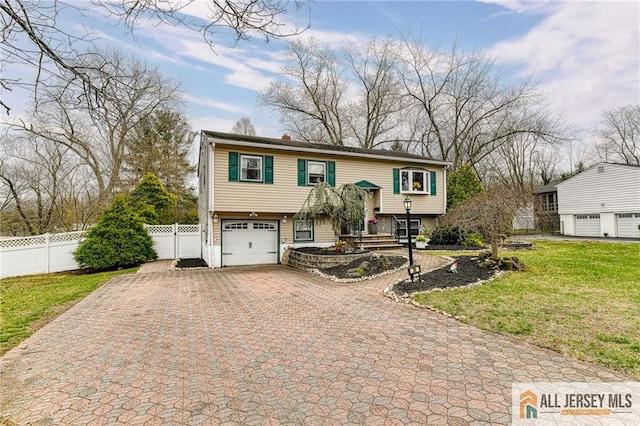 bi-level home featuring decorative driveway and an attached garage