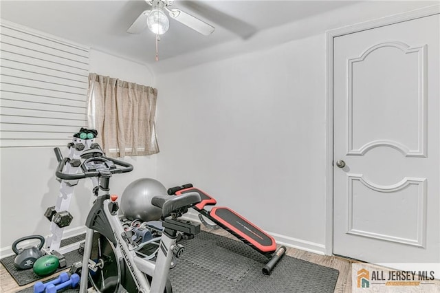 workout room with a ceiling fan, wood finished floors, and baseboards